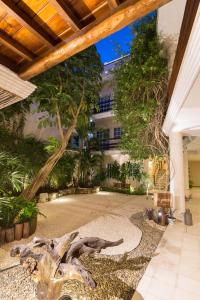 un patio con un árbol y un edificio en Quinta Margarita - Boho Chic Hotel, en Playa del Carmen