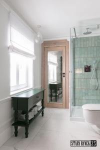 a bathroom with a tub and a sink and a piano at Apartamenty Stary Rynek 25 Toruń in Toruń