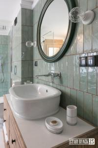 a bathroom with a white sink and a mirror at Apartamenty Stary Rynek 25 Toruń in Toruń