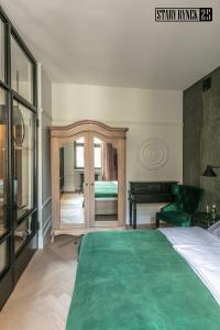 - une chambre avec un grand lit et une couverture verte dans l'établissement Apartamenty Stary Rynek 25 Toruń, à Toruń