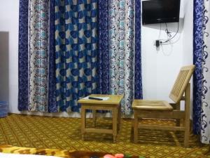 a room with two chairs and a table and a tv at Palay Shay Shay in Leh