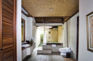 a bathroom with a toilet and a sink and a tub at Sri Phala Resort & Villa in Sanur