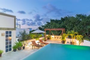 a house with a swimming pool on a patio at Quinta Margarita - Boho Chic Hotel in Playa del Carmen