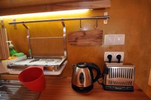 a kitchen counter with a tea kettle and a toaster at Casinha Pim in Horta
