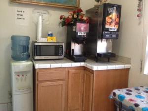 a kitchen with a counter top with a microwave at All 8 Motel in Azusa