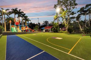 a tennis court with a playground on it at Discovery Parks - Airlie Beach in Airlie Beach