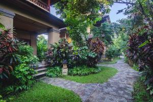 a walkway in front of a house with plants at Sri Phala Resort & Villa in Sanur
