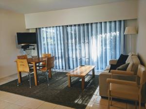 Metung Waters Motel and Apartments في ميتونغ: غرفة معيشة مع أريكة وطاولة
