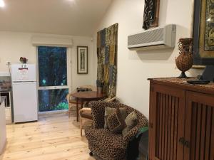 a kitchen and living room with a table and a chair at Weeroona Bed And Breakfast in Rye