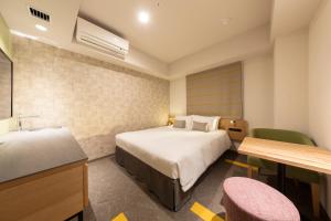 a hotel room with a bed and a sink at Tokyu Stay Sapporo Odori in Sapporo