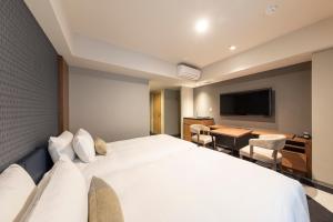 a hotel room with a large bed and a table at Tokyu Stay Sapporo Odori in Sapporo