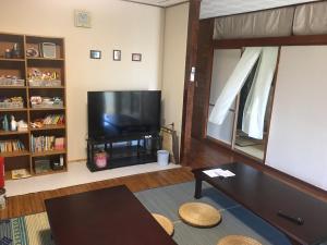 sala de estar con TV de pantalla plana grande en Minnkayado intoparitosura en Isla Miyako