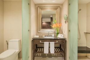 a bathroom with a sink and a mirror and a toilet at Sunsuri Phuket - SHA Plus in Nai Harn Beach
