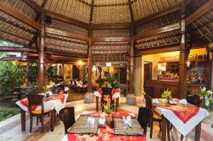 a restaurant with tables and chairs in a building at Sri Phala Resort & Villa in Sanur