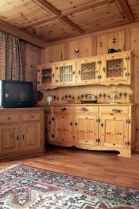 a kitchen with wooden cabinets and a tv in a room at Ferienhaus Silvia in Martello