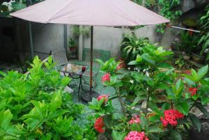 a patio with a table and an umbrella and flowers at Huong Thao 2 Hotel in Ha Giang