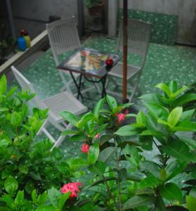 two chairs and a table on a patio with flowers at Huong Thao 2 Hotel in Ha Giang