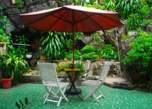 2 chaises et une table avec un parasol dans l'établissement Huong Thao 2 Hotel, à Ha Giang