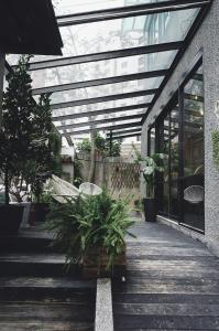 eine Terrasse mit Bänken und Pflanzen in einem Gebäude in der Unterkunft NiHao Café Hotel in Taipeh