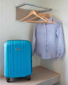 a blue suitcase and a shirt in a closet at Hop Inn Hotel Ermita Manila in Manila