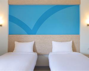 two beds sitting next to each other in a room at Hop Inn Hotel Ermita Manila in Manila