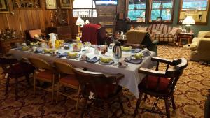 a long table with dishes on it in a living room at Whisperin' Pines Chalet in Cooperstown