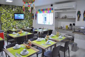a restaurant with tables and chairs with dolls on them at Goyanna Hotel in Goiana