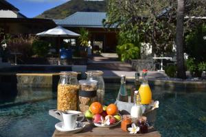 - une table avec de la nourriture et des boissons ainsi qu'un bol de fruits dans l'établissement Shanti Ghar Guest House, à Tamarin