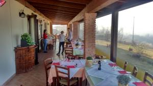 un comedor con mesas y personas en las ventanas en La Casa Di Baba', en Alfiano Natta