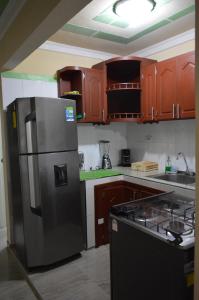 a kitchen with a stainless steel refrigerator and wooden cabinets at The Clover 20-28 in Palmira