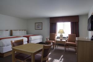a hotel room with two beds and a table at Aladdin Inn and Suites in Portland