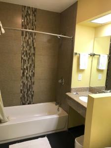 a bathroom with a tub and a toilet and a sink at Colony Inn Motel in Bellflower