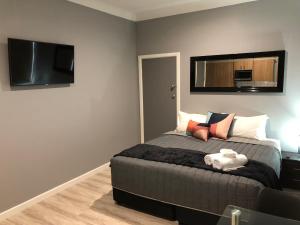 a bedroom with a bed and a flat screen tv at The Mark Studios in Newcastle