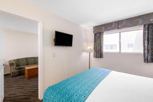 A bed or beds in a room at Howard Johnson Suites by Wyndham San Diego Chula Vista BayFt