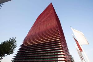 a tall building with a red facade at Best Western Plus Net Tower Hotel Padova in Padova