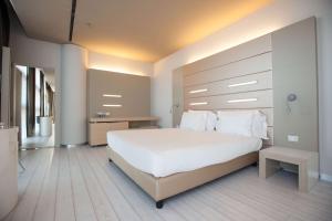 a bedroom with a large white bed with white pillows at Best Western Plus Net Tower Hotel Padova in Padova