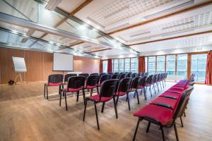 een conferentieruimte met stoelen en een wit scherm bij Best Western Hotel Ile de France in Château-Thierry