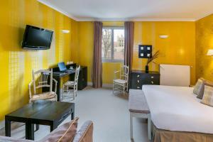 TV a/nebo společenská místnost v ubytování Best Western Hotel Le Guilhem