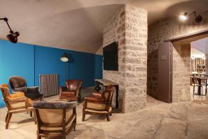 a living room with chairs and a stone fireplace at Best Western Citadelle in Besançon