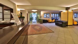 a lobby of a hotel with a reception counter and a living room at Best Western City Hotel in Bologna