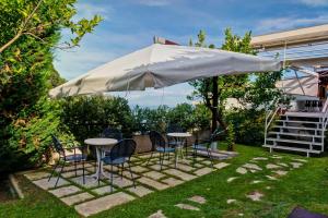 索倫托的住宿－貝斯特韋斯特拉索拉雅酒店，院子里伞下的桌子和椅子