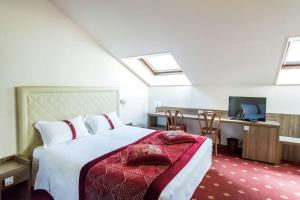 sypialnia z łóżkiem i biurkiem z telewizorem w obiekcie Best Western Hotel Libertà w mieście Modena