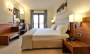 a hotel room with a large bed and a desk and a desk at Suites & Residence Hotel in Pozzuoli