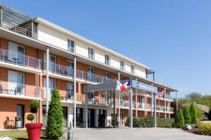 ein Hotel mit Flaggen davor in der Unterkunft Best Western Park Hotel Geneve-Thoiry in Thoiry