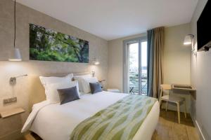 ムン・シュル・ロワールにあるBEST WESTERN La Porte des Châteauxの大きなベッドとデスクが備わるホテルルームです。