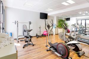 une salle de sport avec plusieurs tapis de course et appareils d'exercice dans l'établissement Best Western Park Hotel Geneve-Thoiry, à Thoiry