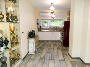a kitchen with white cabinets and a wooden floor at ROYAL apartment in Gabrovo