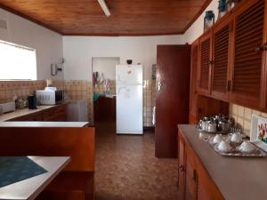 a kitchen with a white refrigerator in a room at Die C Skulp in Hartenbos