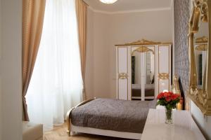 リヴィウにあるLuxury Lviv Apartmentのベッドルーム1室(ベッド1台、鏡、テーブル付)
