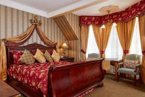 una camera con un grande letto rosso a baldacchino di Queen Anne a San Francisco